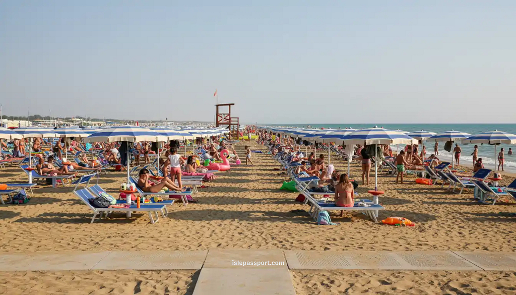 Wide sandy beach with umbrellas and families in Jesolo near Venice