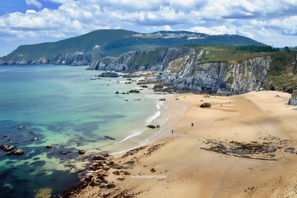 Ortiguera coastline on the northern Spain coast with high cliffs, a long sandy beach, and turquoise Atlantic water.