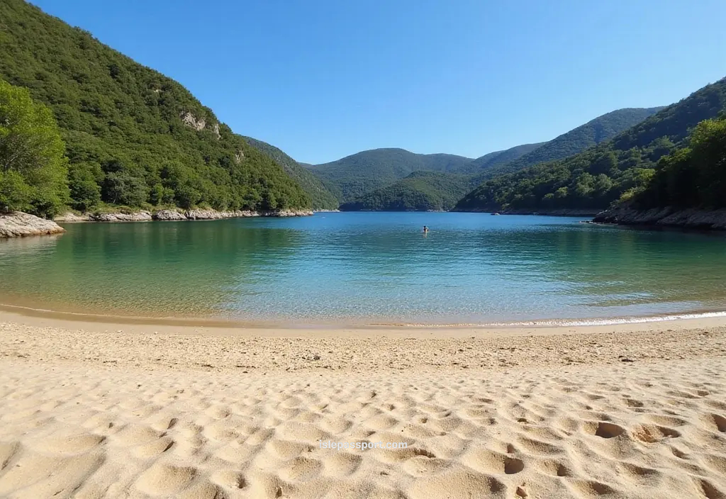 Cala Violina crescent-shaped sandy bay, lush green hills, calm clear water, footprints in the sand.