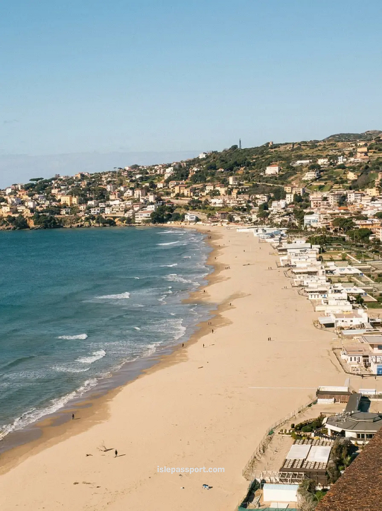 A wide view of the golden sands and clear water at Spiaggia di Serapo in Gaeta, a highlight among the best coastal towns in Italy.