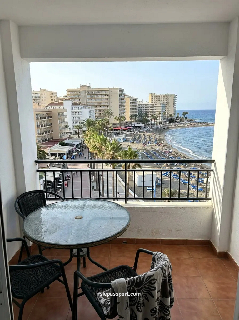 Worn beachfront building on the Costa del Sol with crowded surroundings