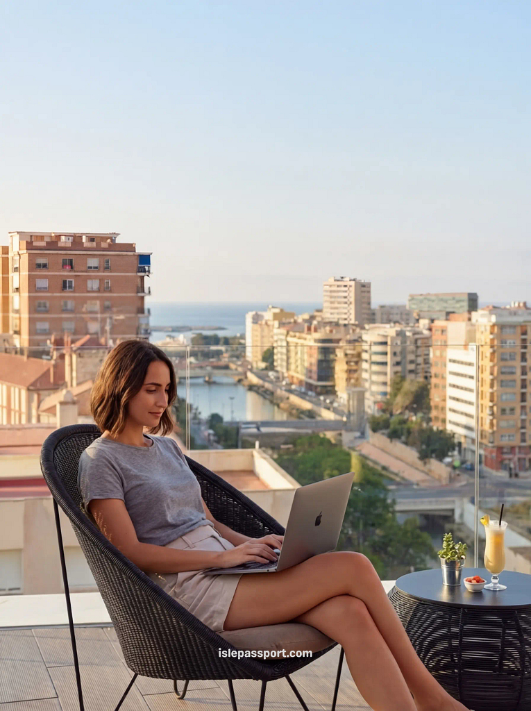 A young woman sits on a rooftop terrace in Málaga, working on a laptop with a view of the city skyline, harbor, and Mediterranean Sea in the background, illustrating the growing digital nomad hub and excellent infrastructure in Spanish coastal cities.