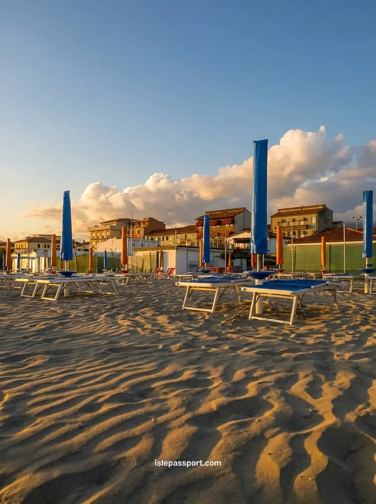 A sandy beach in Viareggio, Italy, with neat rows of sunbeds and vibrant blue umbrellas prepared for visitors.