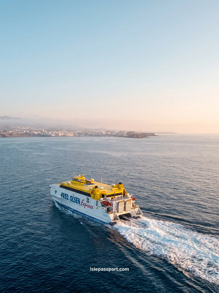 Yellow and white Fred Olsen fast ferry crossing calm blue water between Tenerife and La Gomera, the crossing used for a Tenerife to Gomera day trip