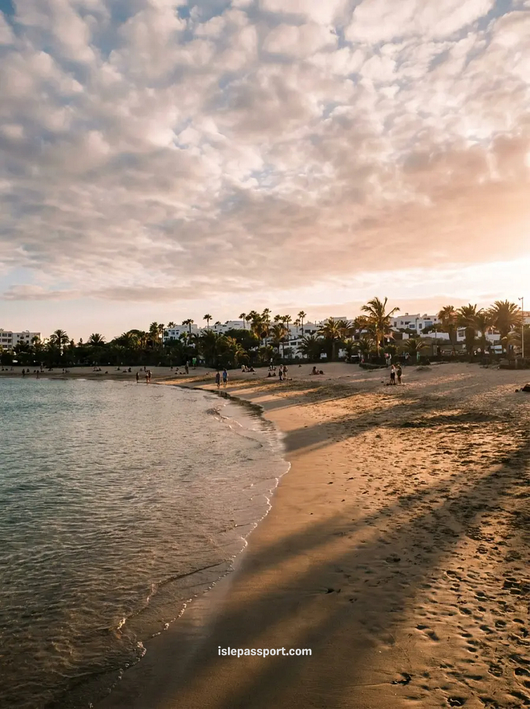 Puerto del Carmen beachfront in Lanzarote in winter at sunset with palm trees and long shadows