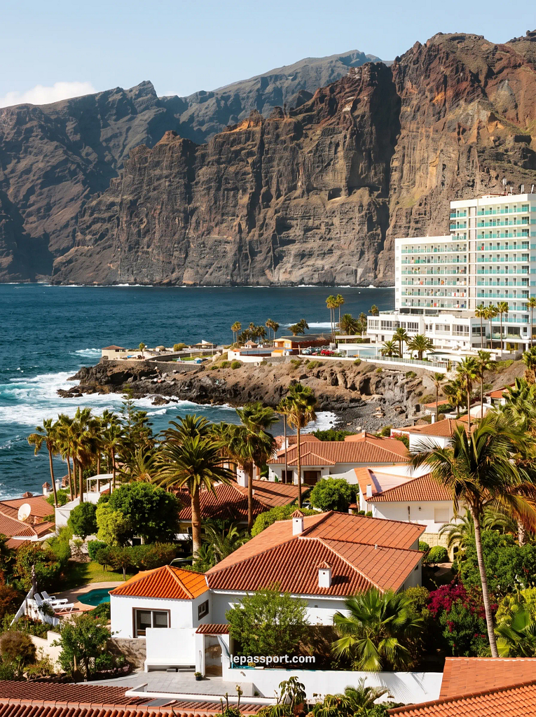 Los Gigantes cliffs rising from the sea above white villas and a hotel on Tenerife's west coast, a Day 6 stop on a Tenerife road trip itinerary