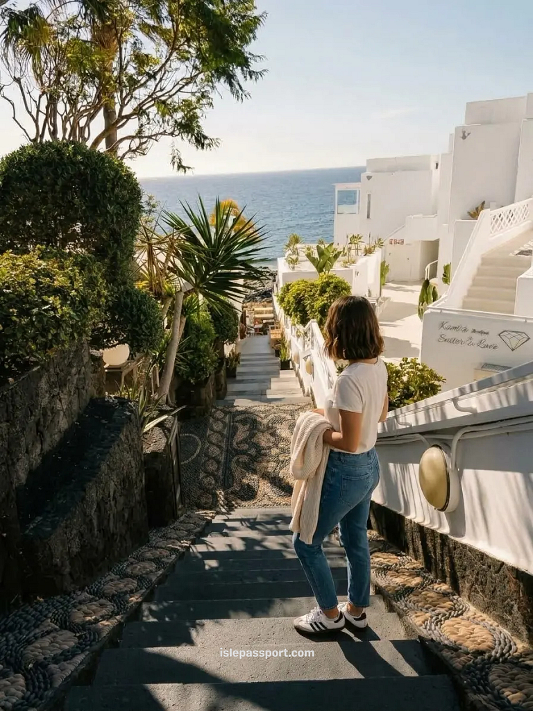Maya walking down pebble mosaic steps between white buildings towards the sea in Puerto del Carmen, Lanzarote